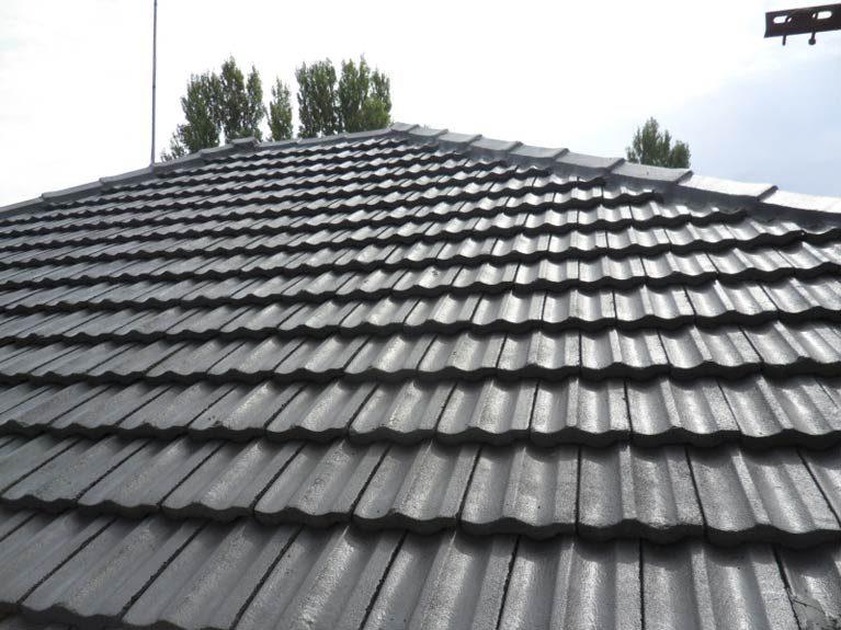 Restored grey tile roof with re-bedded and re-pointed ridge caps