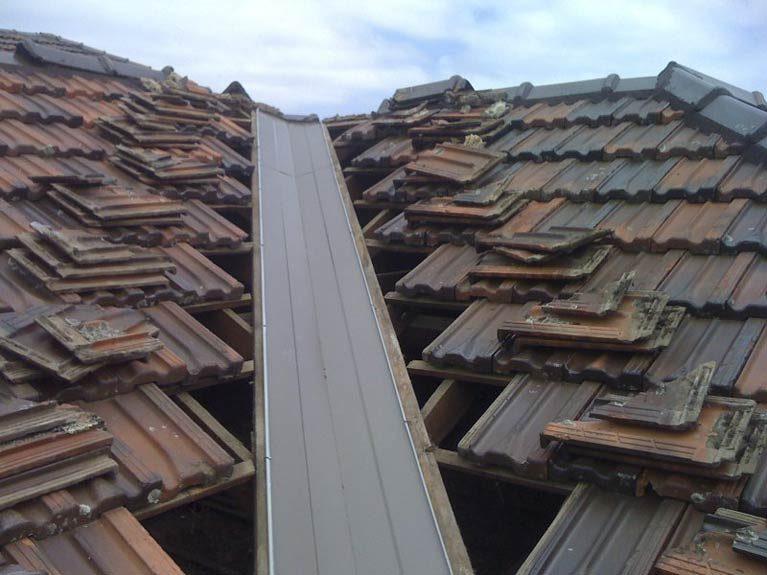 New metal valley iron installed between terracotta roof tiles